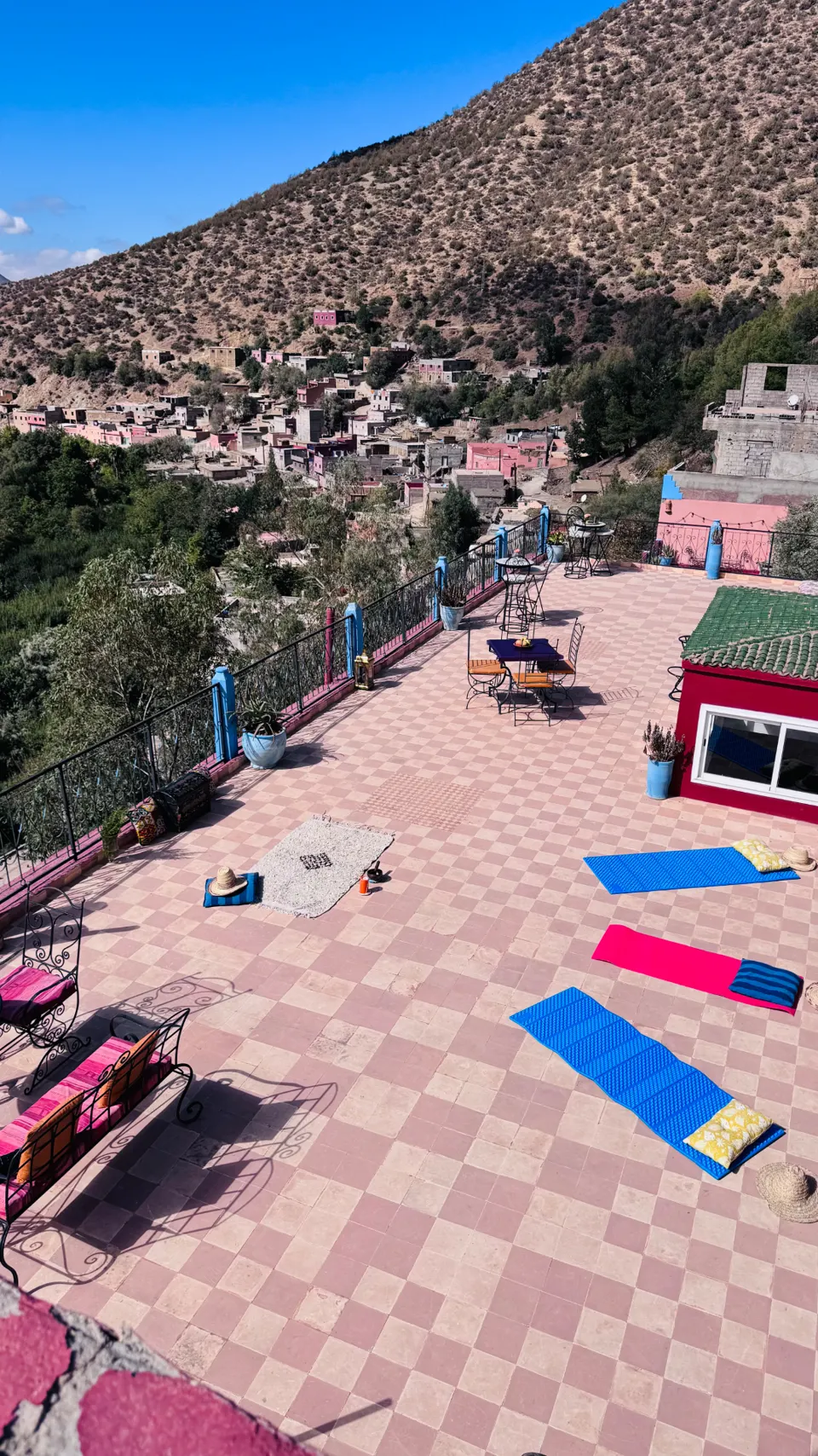 Yoga mats laid out on the panoramic terrace above the village and Atlas foothills