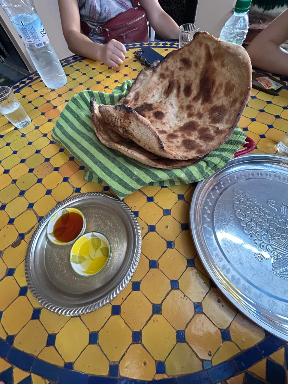 Pain Tanort servi avec huile d'olive et miel sur une table en zellige