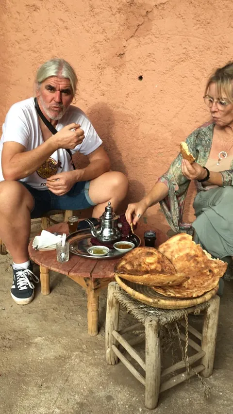 Thé à la menthe, huile d'olive et pain chaud partagés à l'ombre d'un mur de terre rose