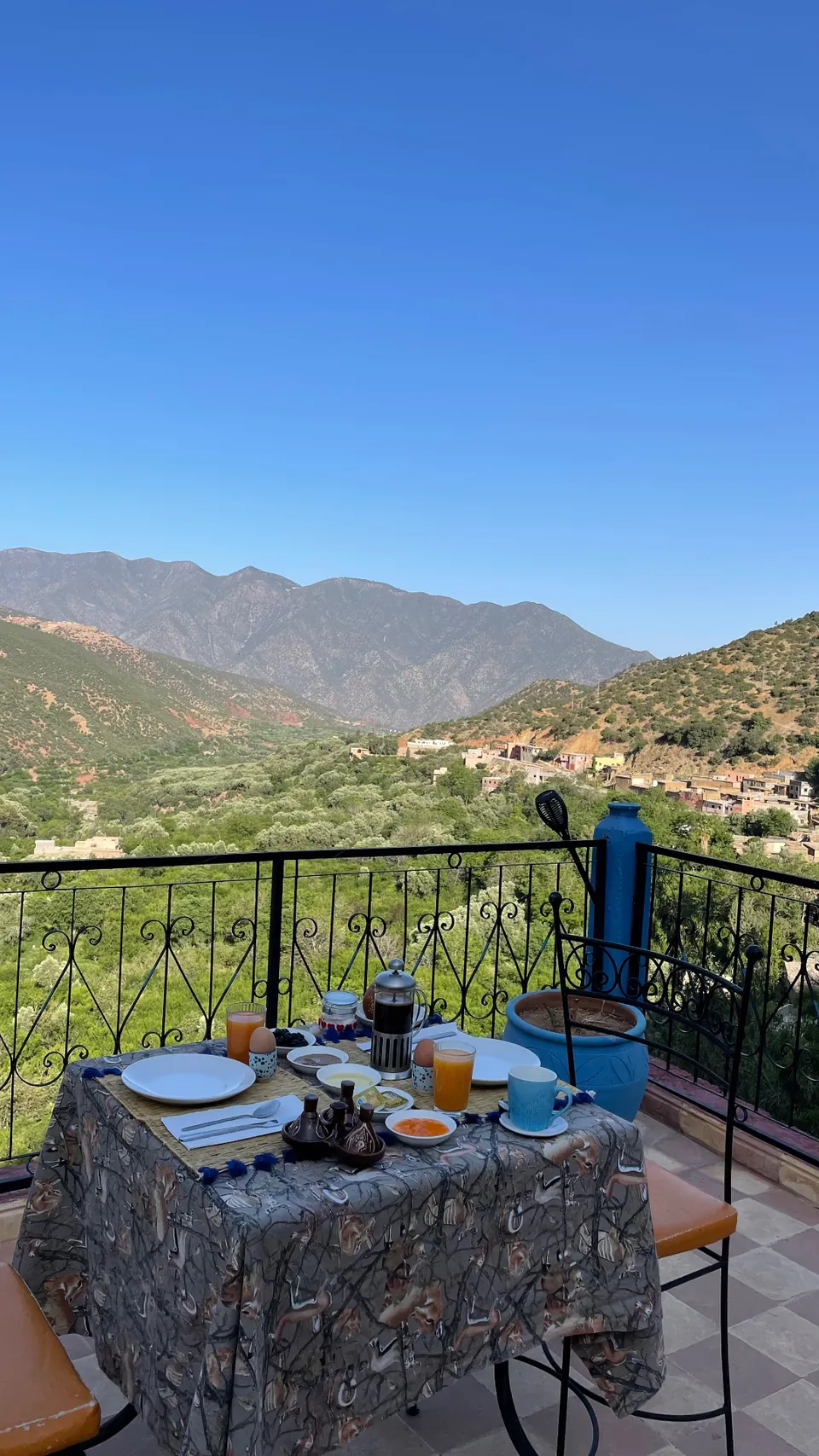Petit-déjeuner dressé sur la terrasse, la vallée d'Azzadin et les cimes de l'Atlas en arrière-plan