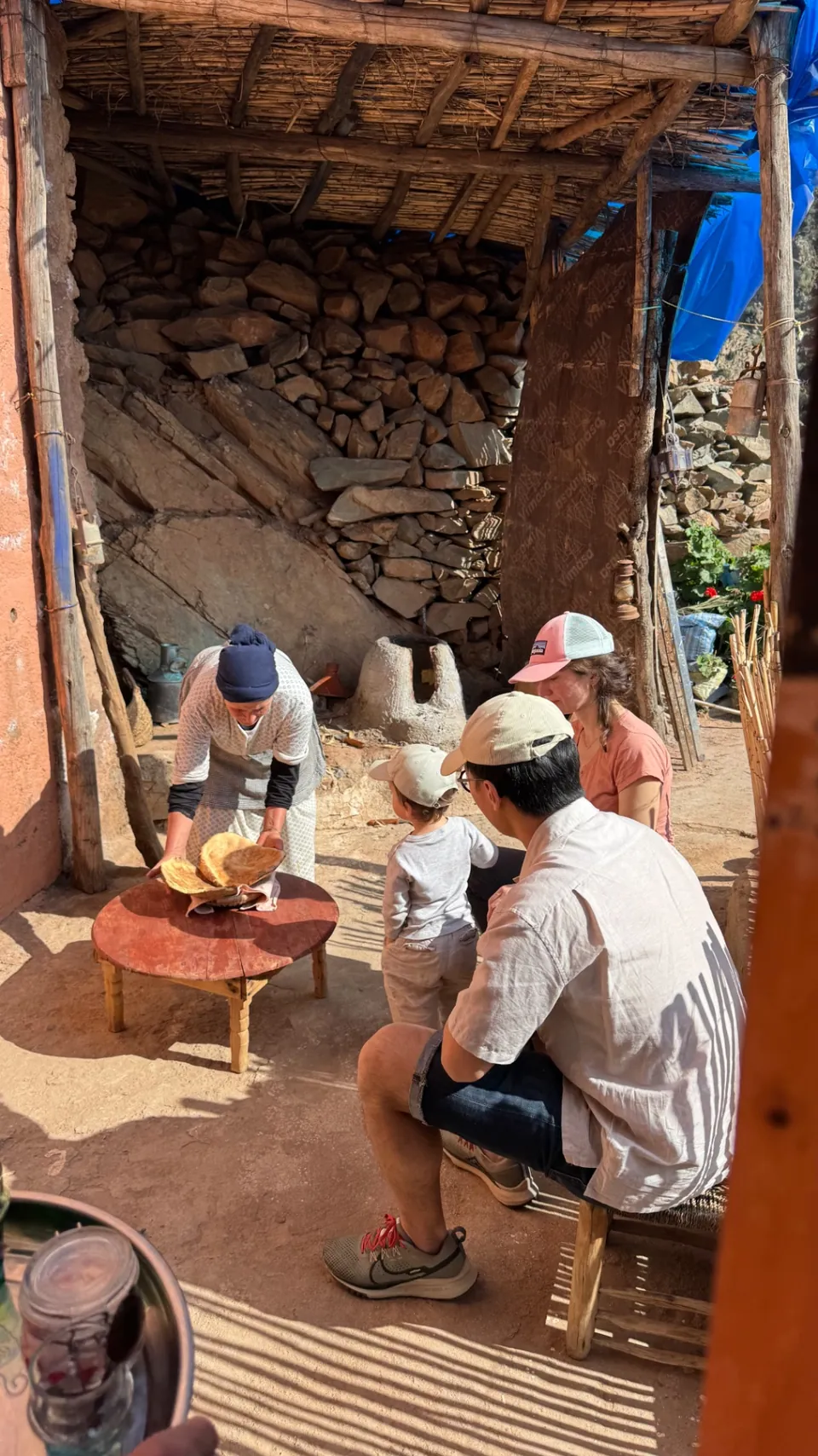 Une voisine amazighe sert le pain cuit dans le four en terre du village aux hôtes de passage