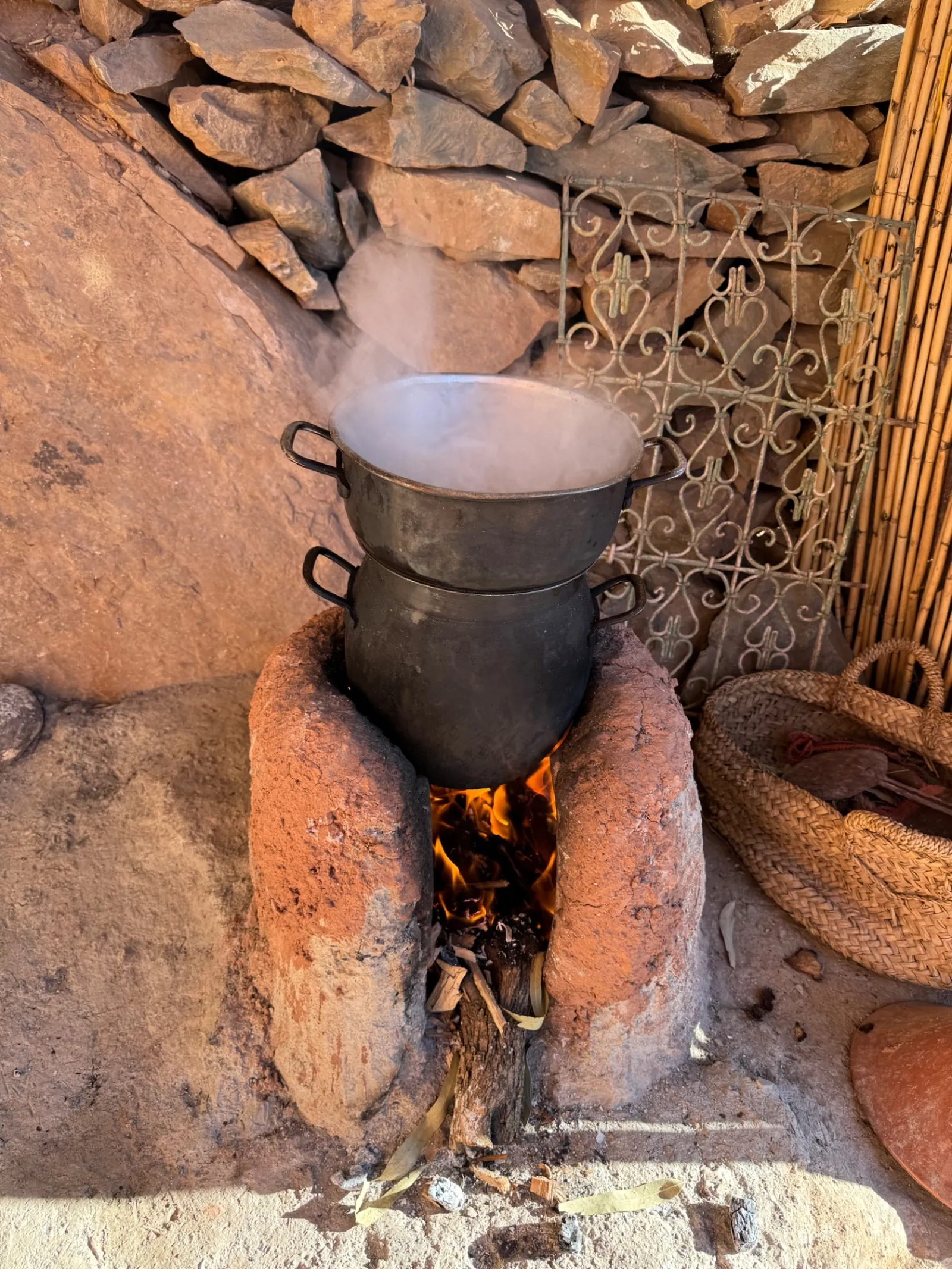 Couscous à la vapeur sur le feu de bois dans un foyer en terre