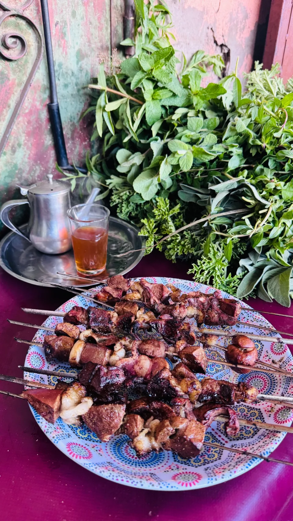 Brochettes grillées servies avec du thé à la menthe et des herbes fraîches
