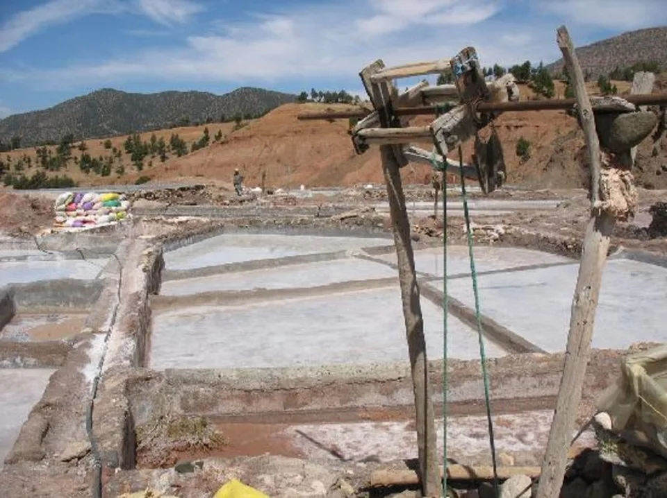 Terraced brine basins fed by wooden draw frames at the Marigha salt works