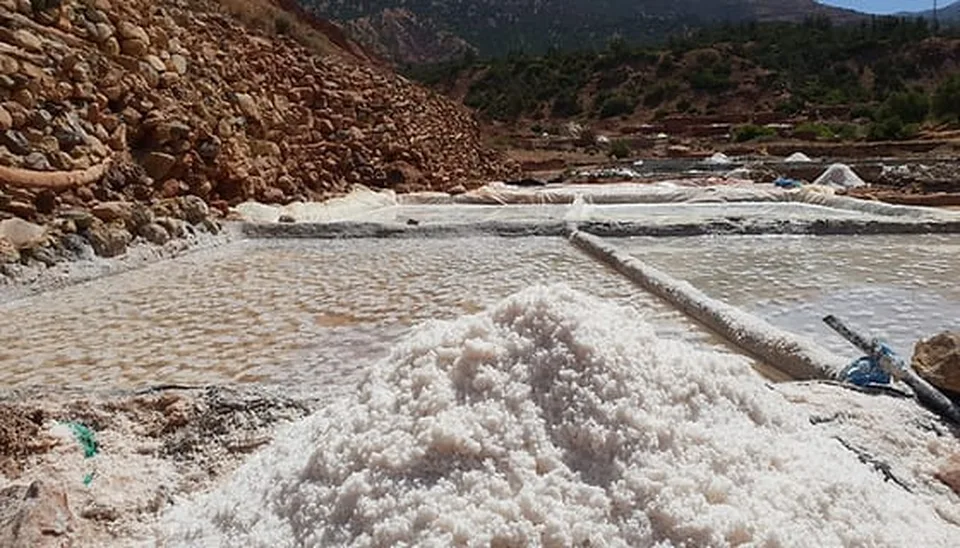 A mound of freshly harvested mountain salt beside the drying pans