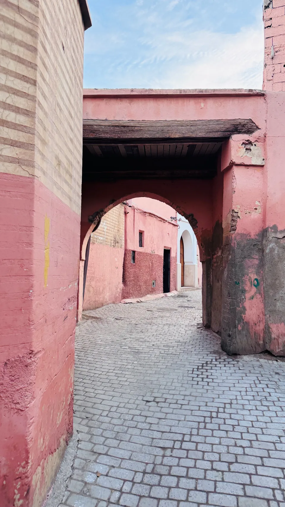 A quiet pink-walled alley and archway in the old medina