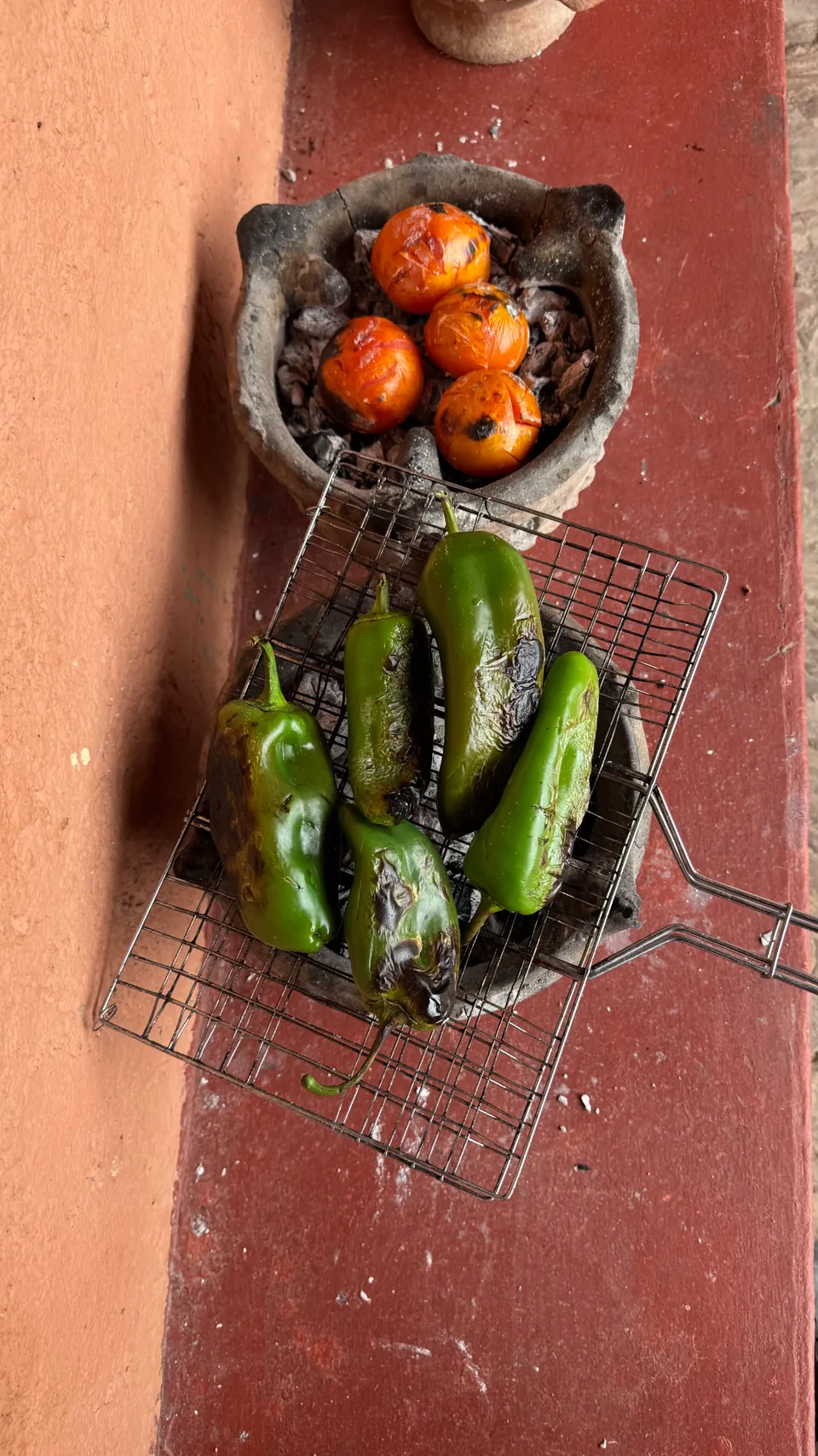 Green peppers and tomatoes charring over charcoal for a smoky salad