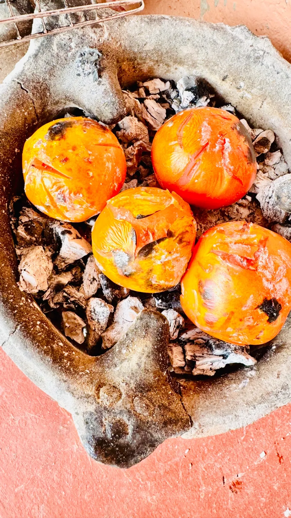 Tomatoes roasting slowly in the embers