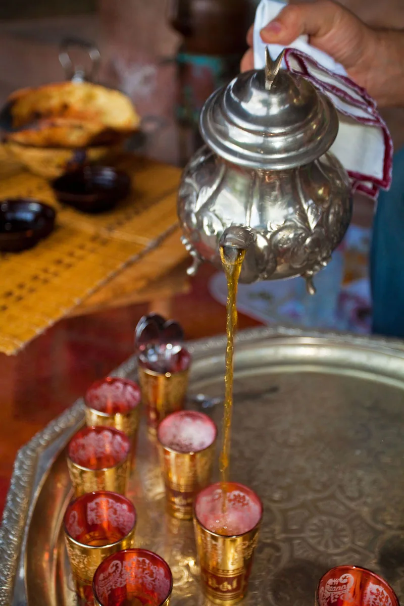 Mint tea poured into engraved glasses on a silver tray