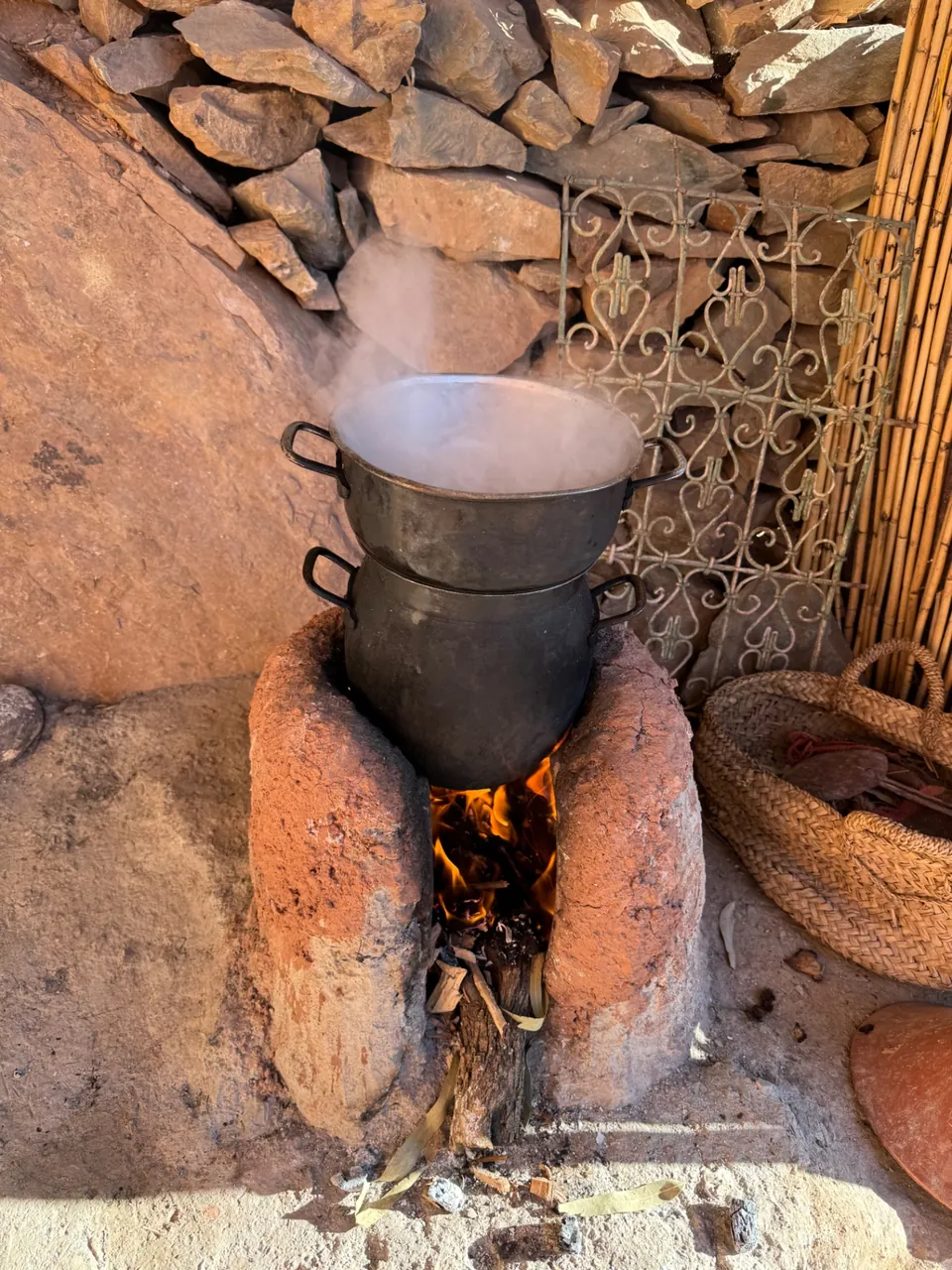 Couscous steaming over a wood fire in the outdoor clay stove