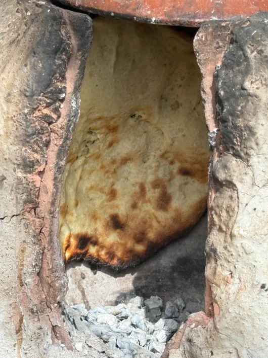Bread baking in the clay wood-fired oven